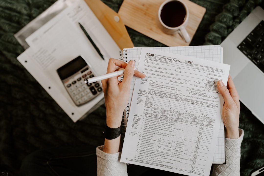 person-reviewing-documents-with-calculator-and-laptop-0ozprxg5hkk